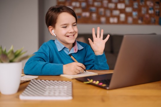 Happy child attending phonics classes online for kids